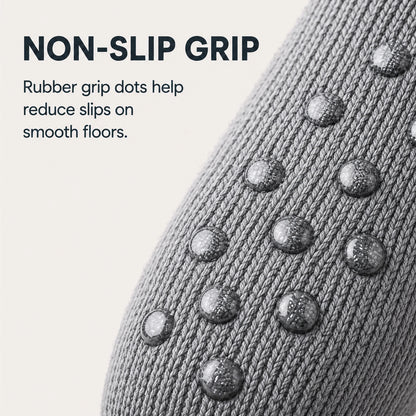 Close-up of a gray knit sock with raised rubber grip dots on a light beige background, with text reading 'NON-SLIP GRIP' and a descriptive feature callout.